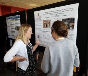 Brittany Peterson, left, presents her poster on foraging toys for laboratory rhesus macaques at the American Society of Primatologists meeting in Madison last August. (J. Lenon photo)